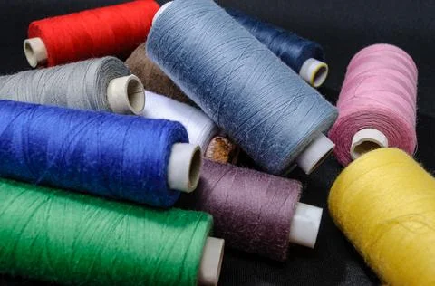 Colorful spools of thread on black background Stock Photos