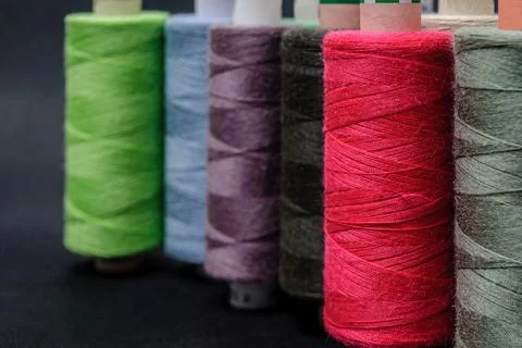 Colorful spools of thread on black background Foto stock