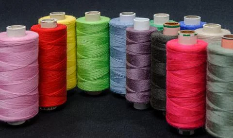 Colorful spools of thread on black background Stock Photos