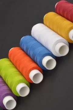 Colorful spools thread on dark background Stock Photos