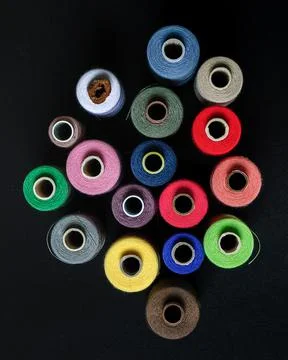 Colorful spools of thread top view on black background 写真素材