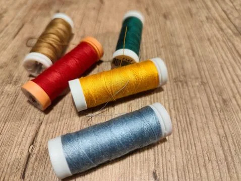 Colorful spools of thread on wooden background Stock Photos