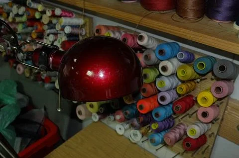 Colorful Spools In Warm Light. Workshop With Glowing Red Illumination And O.. Foto stock
