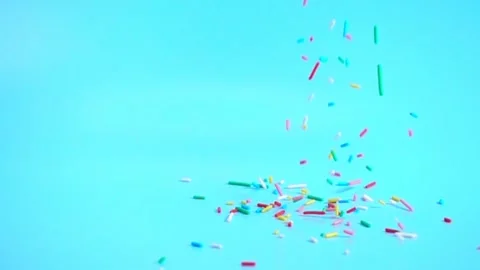 Colorful sprinkles falling on blue background, decoration for cake and bake.. Stock Footage 328398222