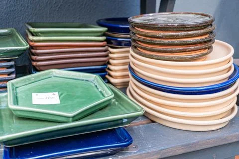A colorful stack of ceramic plates displayed in a market or retail setting .. 스톡 사진