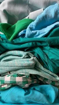 Colorful stack of clothes including various shades of green and blue found .. Stock Photos