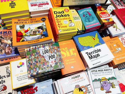 Colorful stack of funny books, maps and cartoons on a busy bookstore table Stock Photos
