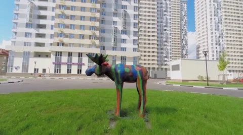 Colorful statue of elk on grassplot and survey crew Vidéo 47638638