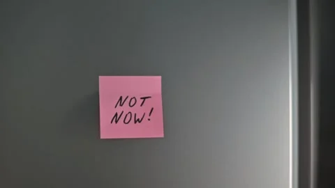 A colorful sticky note is placed on a door, repeatedly sending a message of Not Stock Footage 339096640