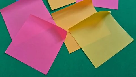 Colorful sticky notes on green background. Bright adhesive paper sheets for Stock Photos