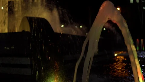 Colorful streams of water in fountain at night time, super slow motion. Stock Footage 89973653