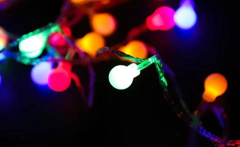Colorful string lights glowing in a dark background Stock Photos