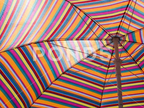 Colorful striped beach umbrella. Hot weather. A beach holiday. Striped texture Stock Photos