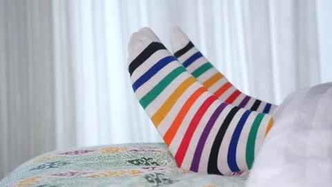 Colorful striped socks on a bed during a cozy morning Stock Footage 314207007