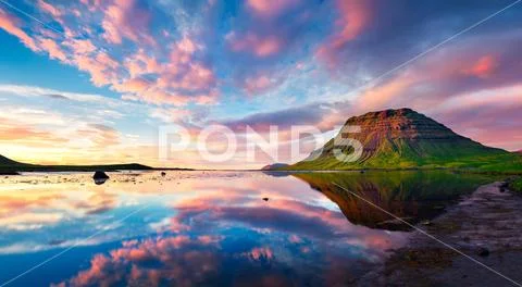 Colorful summer sunset with Kirkjufell Mountain in Grundarfjordur town Stock Photos