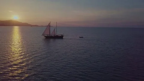 Colorful sunset above the sea surface with sail boats, aerial view. Sunset over Stock Footage 174032167