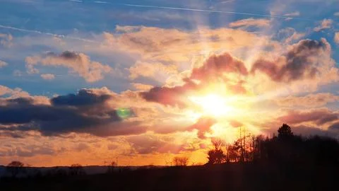 Colorful sunset background with abstract clouds and trees. Photos