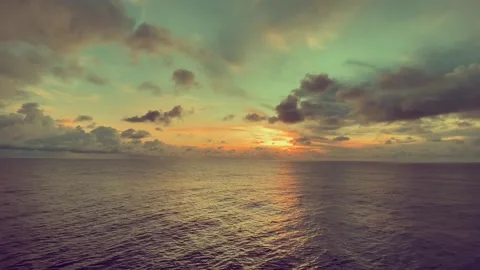 Colorful sunset over the ocean with vibrant clouds reflecting light in the .. Stock Footage 338280296