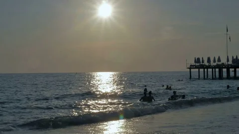 Colorful sunset. Sea view with waves and foam, pier and pebble beach Видео 80367597