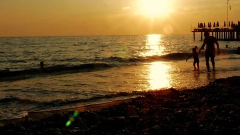 Colorful sunset. Sea view with waves and foam, pier and pebble beach Stock Footage 80369582