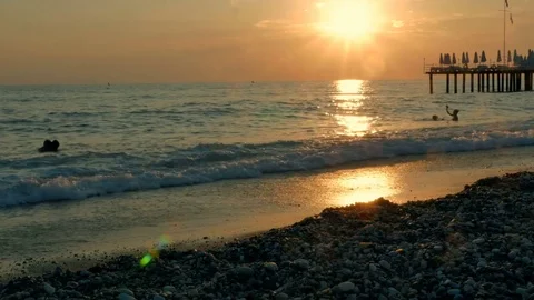 Colorful sunset. Sea view with waves and foam, pier and pebble beach Stock Footage 80412132