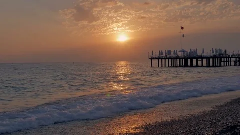 Colorful sunset. Sea view with waves and foam, pier and pebble beach. time lapse Stock Footage