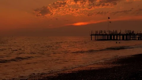 Colorful sunset. Sea view with waves and foam, pier and pebble beach. time lapse Stock Footage 80588534