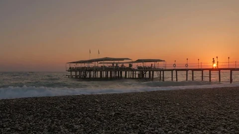 Colorful sunset. Sea view with waves and foam, pier and pebble beach 動画素材 82291965