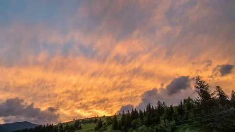 Colorful sunset sky and clouds afterglow. Sun setting above mountains silhouette Video stock 77552689