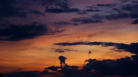 Colorful sunset sky with dark cloud silhouettes and a gradient from deep blue Stock Footage 343781503