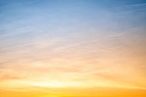 Colorful sunset sky with soft clouds and warm glow Stock Photos