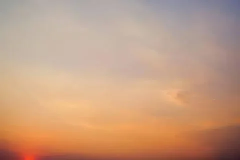 Colorful sunset sky with soft clouds and warm hues Stock Photos