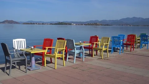 Colorful table and chairs at the seafront Stock Footage 79316284
