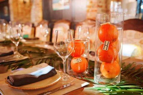 Colorful table setting with oranges and glasses in a warm dining space 写真素材