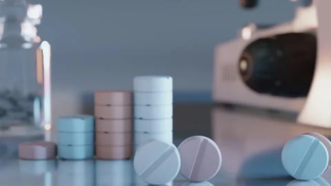 Colorful tablets are rolling across a pharmacist's desk. 3d rendering Stock Footage 294572106