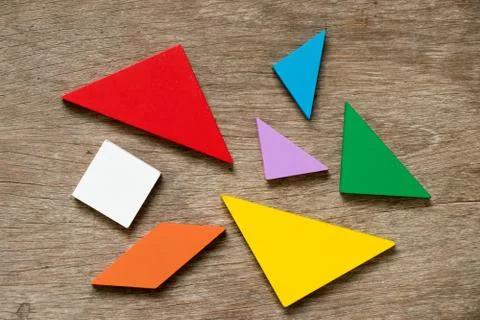 Colorful tangram puzzle wait to develop shape on wood background 스톡 사진