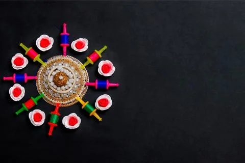 Colorful thread spools arranged in circular pattern on black background with dec 写真素材