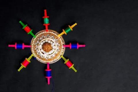 Colorful thread spools arranged in circular pattern on black background with dec 스톡 사진