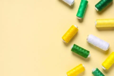 Colorful thread spools on beige background 写真素材