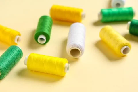 Colorful thread spools on beige background 写真素材