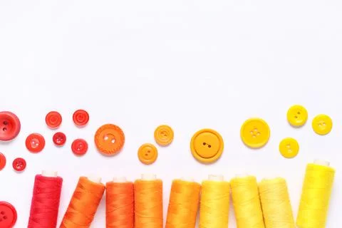 Colorful thread spools with buttons on white background 写真素材