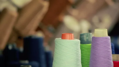 Colorful thread spools closeup textile factory. Yarn cone rack garment workshop. Stock Footage 345920163