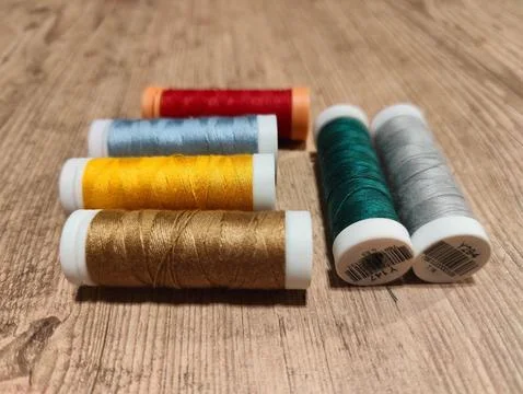 Colorful thread spools on wooden table Stock Photos