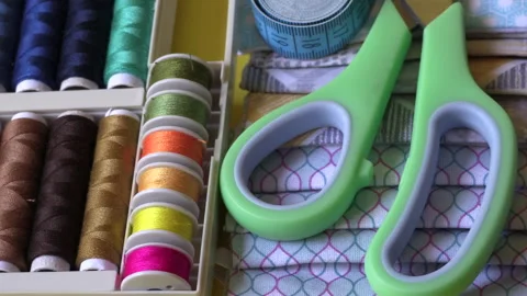 Colorful threads, scissors, designed fabric patterns and measurement tape at tai Stock Footage 132363466