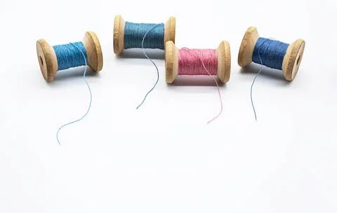 Colorful threads for sewing. Different threads on wooden vintage reels. Stock Photos