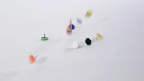 Colorful thumbtacks falling on white background Stock-Footage 114348216