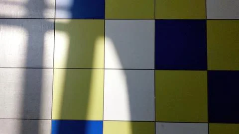 Colorful Tiled Floor With Shadow Patterns Creating Visual Contrast in a Wel.. Stock Photos