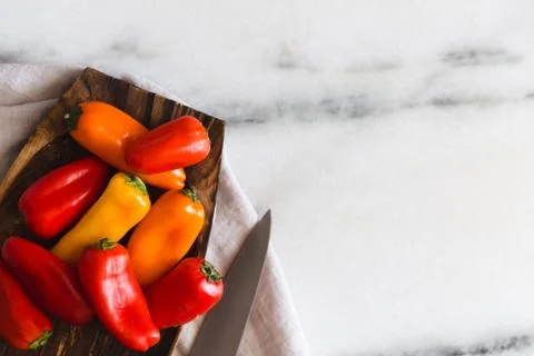 Colorful tiny bell peppers on a marble surface Stock Photos