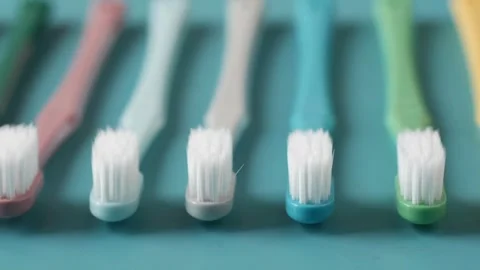 Colorful toothbrushes aligned on a blue background Stock Footage 333740817