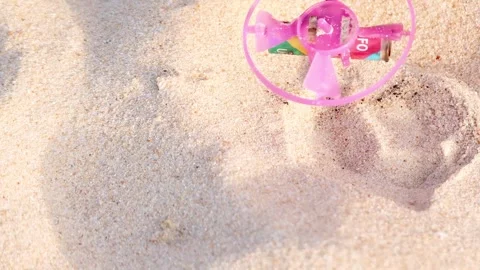 Colorful Toy Spinning on Sandy Surface Vídeos de archivo 308501839